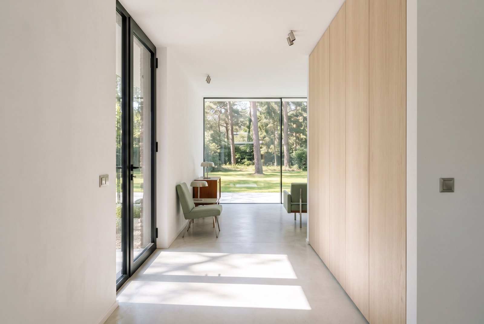 View from the entrance along a wall of ash joinery to a glass wall onto the lawn