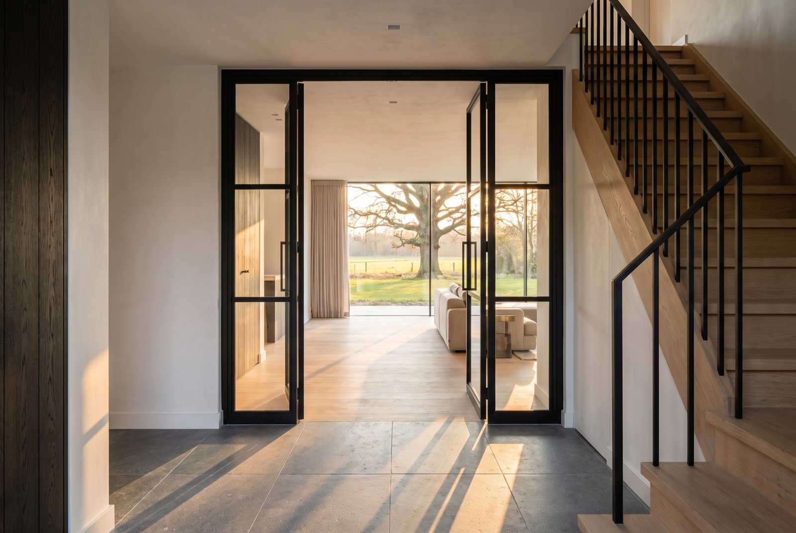 View from the entrance hall with a bluestone floor through to a glazed wall onto the meadow