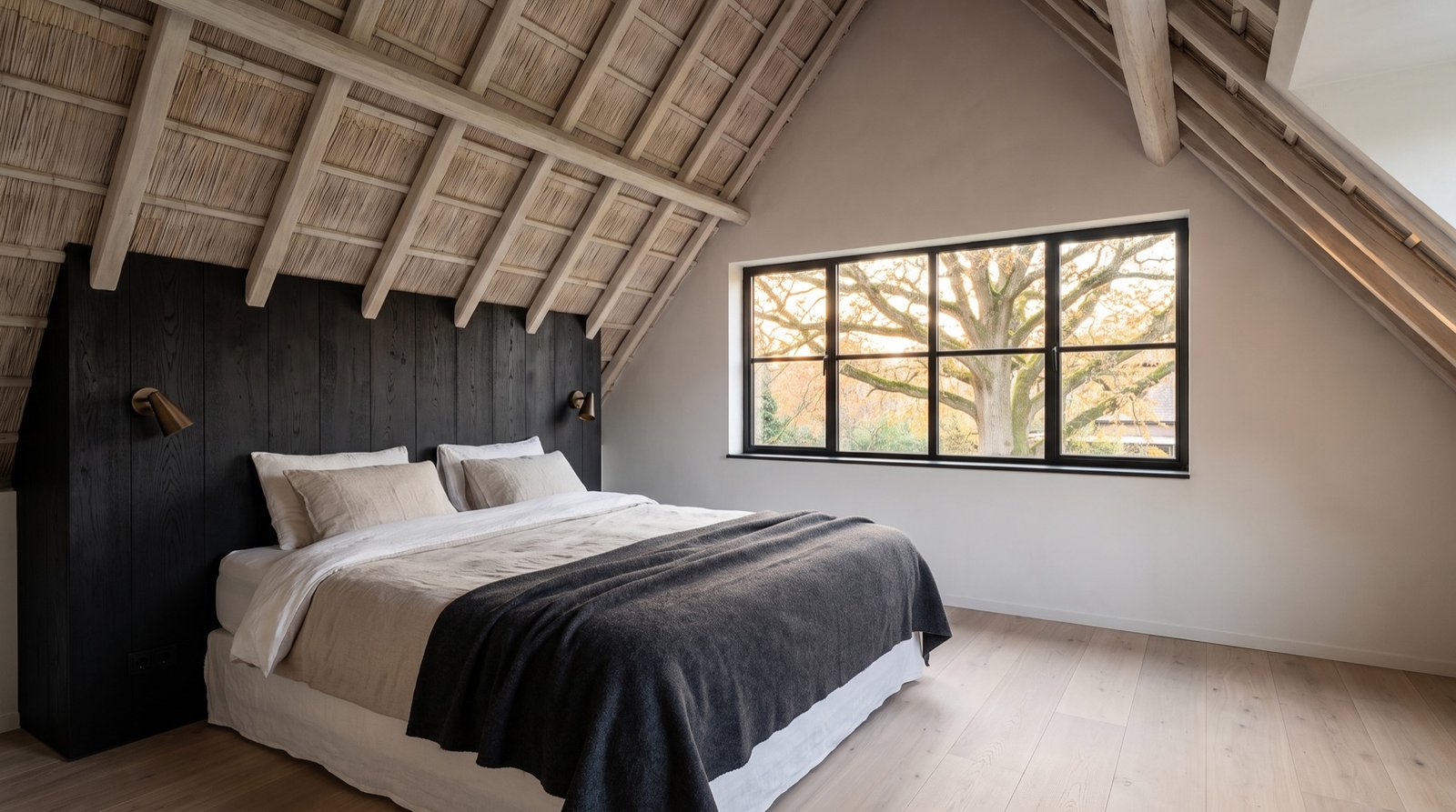 Bedroom under lime-washed rafters and thatch with linen bedding and a black oak headboard