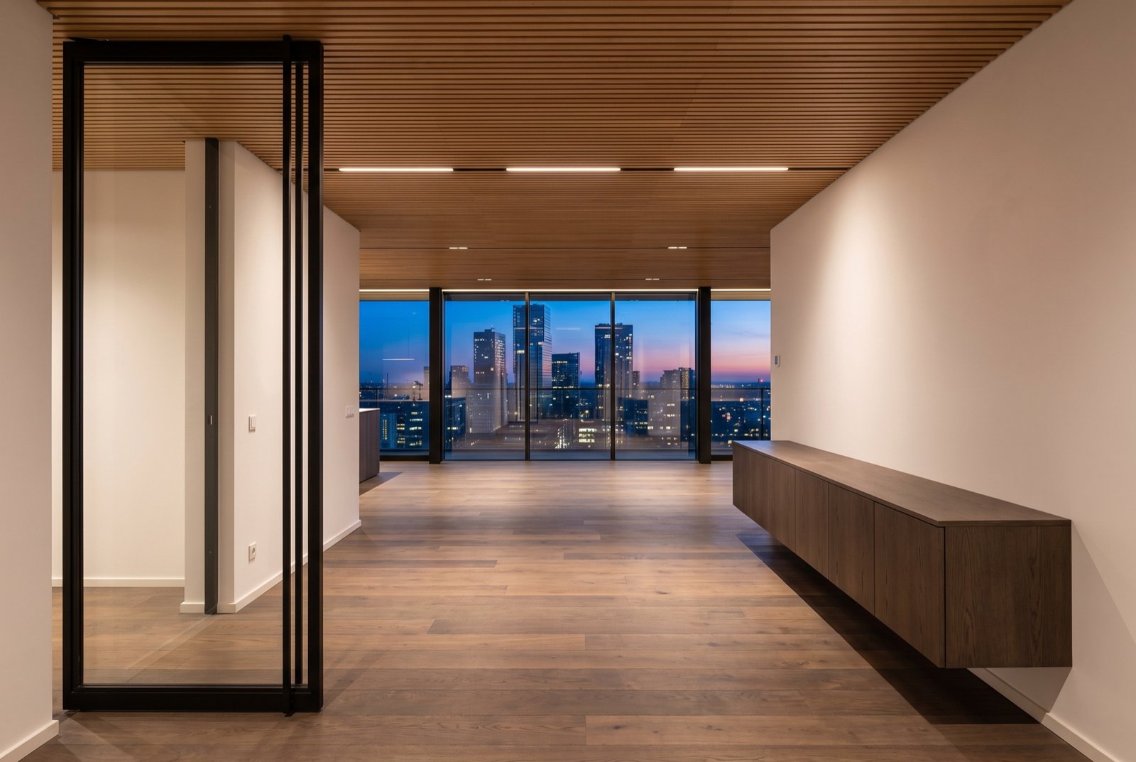 View from the front door down one open floor to a glass wall and the skyline
